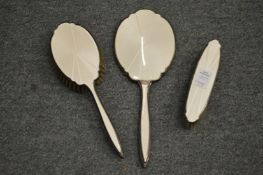 A silver and enamel three-piece dressing table set.