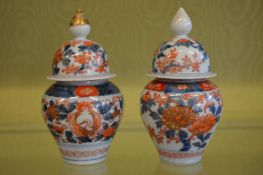 A near pair of small Imari vases and covers.