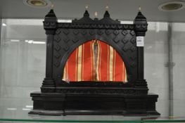 A small Indian ebonised table screen inset with a painting of an erotic scene with pierced silver