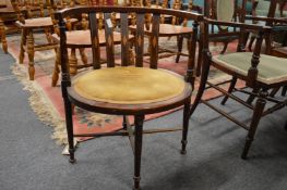 An Edwardian inlaid mahogany horseshoe shaped armchair.