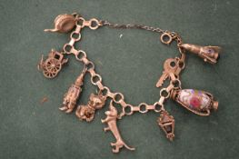 A 9ct gold charm bracelet with numerous charms.