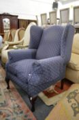 A large blue upholstered wing armchair.