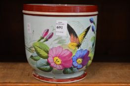 A French porcelain jardiniere decorated with flowers and insects.