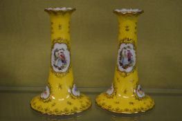 A pair of yellow porcelain candlesticks.