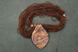 A decorative Japanese lacquer pendant and chain.