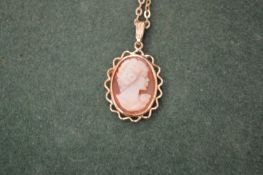 A gold chain with cameo pendant.