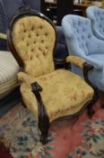 A Victorian button upholstered mahogany framed open armchair.