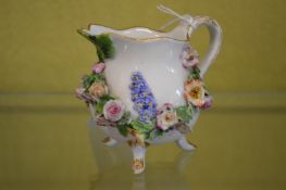 A small Meissen floral encrusted jug.
