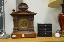 A mantle clock and a miniature chest of drawer.