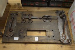 A mounted display of wrought iron door furniture.