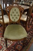 A Victorian carved walnut and upholstered occasional chair.