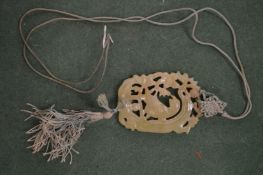 An archaic style Chinese carved and pierced jade pendant.