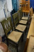 A set of four modern green stained rush seated dining chairs.