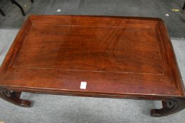 A Chinese rosewood low table with curving ends.
