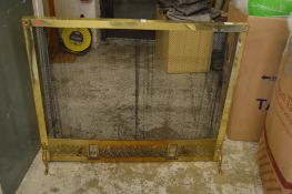 A brass and mesh fire screen.