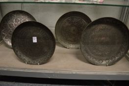 Four early Islamic engraved silvered copper dishes.
