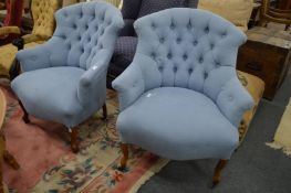 A pair of pale blue upholstered button back armchairs.