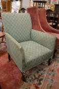 An Edwardian small upholstered armchair made by Shoolbred.