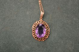A gold chain with an amethyst pendant.