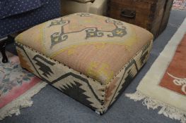 A large Kilim upholstered footstool.