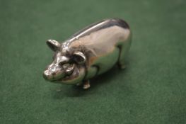 A silver pig shaped vesta.