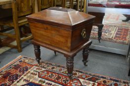 A good Regency mahogany sarcophagus shaped cellarette on turned and reeded legs with brass castors.