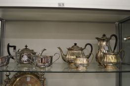 A silver plated three-piece tea service and a plated four-piece tea service with engraved