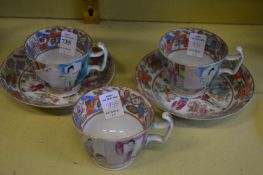 A pair of Chinese Canton cups and saucers and another single cup.