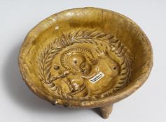 AN EARLY FRENCH STONEWARE JELLY MOULD BOWL with a head and arms. 7ins diameter.