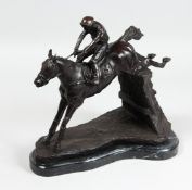 A BRONZE HORSE AND JOCKEY OVER A FENCE. 12ins high on a marble base.