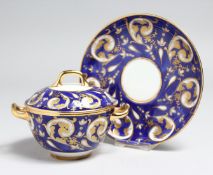 A CONTINENTAL PORCELAIN SUCRIER, COVER AND STAND with blue and gilt borders.