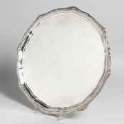 A GOLDSMITH & SILVERSMITH CIRCULAR SALVER with cast border on three pad feet. 12ins diameter. London