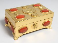 A GOOD GILT METAL JEWEL BOX set with hardstones and Egyptian motifs supported on claw feet. 8ins