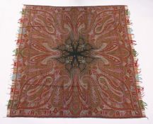 A KASHMIRI TEXTILE/SHAWL, woven in reds and greens, with a radiating design. 5ft 10ins x 5ft 8ins.