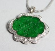 AN 18CT GOLD JADE AND DIAMOND PENDANT on a chain.