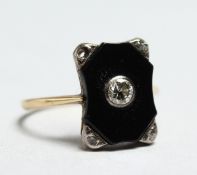 AN ART DECO ONYX AND DIAMOND RING.
