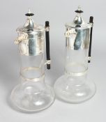 A PAIR OF CHRISTOPHER DRESSER DESIGN SILVER PLATED CLARET JUGS.