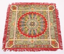 AN ISLAMIC WOOL TABLE CARPET with a central radiating design within borders decorated with