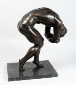 A BRONZE MAN BENT OVER on a marble base. 16ins high.