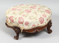 A VICTORIAN CARVED WALNUT AND UPHOLSTERED SMALL CIRCULAR FOOTSTOOL. 13.5ins diameter.