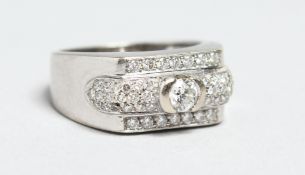 AN 18CT WHITE GOLD AND DIAMOND RING with a central single stone flanked by small diamond clusters