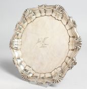 A GEORGE II SALVER crested with shell and gadrooned edge. 6ins diameter. London 1742. Maker H.B.