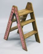 A PAINTED WOOD LADDER with champagne names.