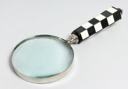 A MAGNIFYING GLASS with chequered handle.