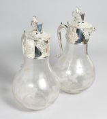 A GOOD PAIR OF PLATED LION TOP CLARET JUGS engraved with fruiting vines.
