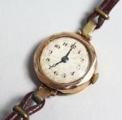 A LADIES 9CT GOLD WRIST WATCH with leather strap.