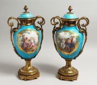 A VERY GOOD PAIR OF 19TH CENTURY SEVRES PALE BLUE, TWO HANDLED URNS AND COVERS, painted with reverse