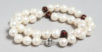 A STRING OF PEARLS with diamond and emerald sections.