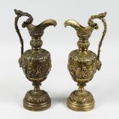 A PAIR OF GILT BRONZE CHERUB EWERS on circular bases.