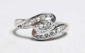 A 9CT WHITE GOLD ZIRCON TWIST RING.